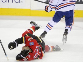 Calgary Flames Matt Stajan collides with Edmonton Oilers Keith Aulie during their game at the Scotiabank Saddledome in Calgary on December 31, 2014.