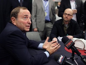NHL Commissioner Gary Bettman talks with the media, including Calgary Herald reporter Scott Cruickshank, background, during a press conference at the Scotiabank Saddledome  on Thursday.