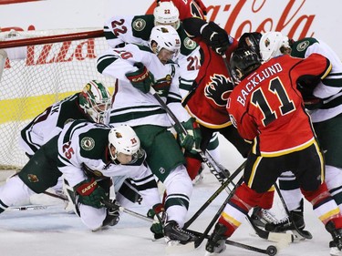 Calgary Flames a and Minnesota Wild pile up in a wild melee in front of the Wild net during the third period of NHL action at the Scotiabank Saddledome on Thursday Jan. 29, 2015. The Wild won the game 1-0.