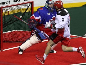 Calgary Roughnecks Dan MacRae gets the ball past Toronto Rock's goalie Nick Rose to score at the Scotiabank Saddledome, in Calgary on March 1, 2014.