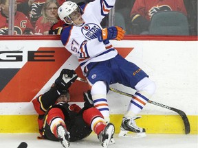 Calgary Flames TJ Brodie collides with Edmonton Oilers David Perron, right, during their game at the Scotiabank Saddledome in Calgary on December 31, 2014.