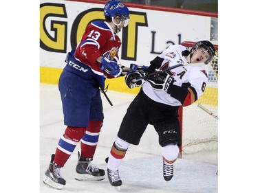 Colby Harmsworth of the Calgary Hitmen takes a cross check from Brandon Baddock of the Edmonton Oil Kings in front of the Calgary net during the second period of WHL action Saturday January 31, 2015 at the Saddledome.