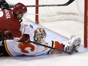 Calgary Flames goalie Joni Ortio, right, makes a spectacular save on a shot by Arizona Coyotes' Sam Gagner during the first period on Thursday night.