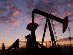 An oil pump jack is silhouetted against the sunrise at the southeast outskirts of Calgary.