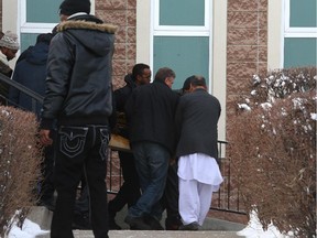 Mourners leave the funeral home carrying the body of Abdullahi Ahmed, who was killed in a shooting at a party on January 1.