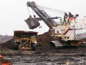 A truck is loaded with ore at the Athabasca Oil Sands Project north of Fort McMurray. Operator Shell Canada says it will cut five to 10 per cent of its staff there.