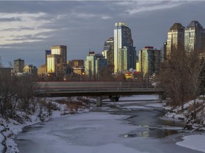 A sunset view of the Calgary downtown skyline, as the C-train crosses a bridge.