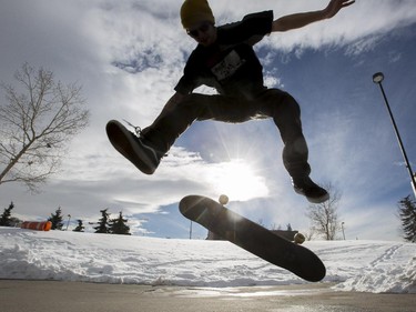 Kyle Michalski, takes advantage of the tempid February day and skate boards at Millennium Park in Calgary, on February 7, 2015.