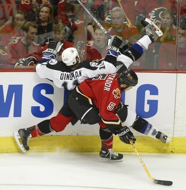 Tampa Bay's Chris Dingman is taken into the boards by Calgary Flames Steve Montador  in the first period of game 4 of the Stanley Cup Finals, May 31, 2004.