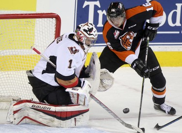 Calgary Hitmen netminder Brendan Burke, left, stops a shot on net from Medicine Hat Tigers netminder Markus Eisenschmid, right, during their game at the Scotiabank Saddldome.