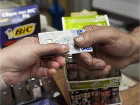 A consumer pays with a credit card at a store  in Montreal.