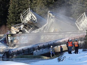 Banff firefighters spray water to keep dust down as CP crews dealt with a 7-car train derailment in Banff at the rail bridge over 40 Mile Creek.