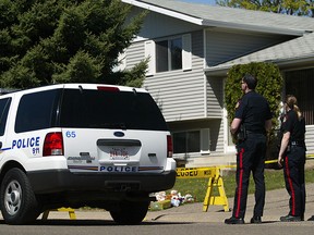 Police outside the house in 2006 where "J.R." helped her 23-year-old boyfriend, Jeremy Allan Steinke, murder her Medicine Hat parents and eight year-old brother.