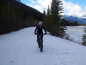 Belinda Milne, an avid mountain biker, enjoys her first time riding a fat bike alongside the Bow River on a warm Sunday in Banff. Just a moment after this photo was snapped, two moose crossed the river.