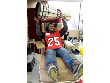 Calgary Stampeders Keon Raymond brings the grey Cup to the Canadian Blood Services clinic in Calgary on February 4, 2014.