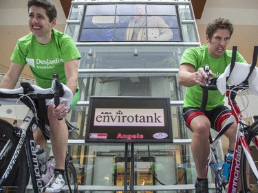 Martin Dodd, left, organizer of the third annual CANSuffer to Conquer event, and Mike Beauchamp, near the end of their 24 consecutive hour stationary bike ride to raise money for the fight against cancer at the Southcentre Mall in Calgary, on February 28, 2015.
