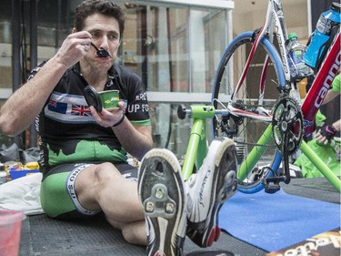 Martin Dodd, organizer of the third annual CANSuffer to Conquer event, fuels his body with some food as he nears the end of his 24 consecutive hour stationary bike ride to raise money for the fight against cancer at the Southcentre Mall in Calgary, on February 28, 2015.