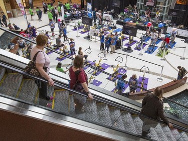 Shoppers on the escalator watch the participants of the 2015 CANSuffer to Conquer event, in which participants ride for up to 24 consecutive hours to raise money for the fight against cancer at the Southcentre Mall in Calgary, on February 28, 2015.