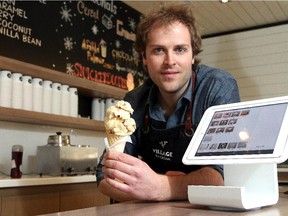 Billy Friley, owner of Village Ice Cream, holds a big scoop alongside the ipad that he runs the Square app for payment on Thursday February 19, 2015.