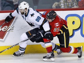 San Jose Sharks' Brent Burns, left, battles with Calgary Flames' Mason Raymond during their Feb. 4 meeting last week.