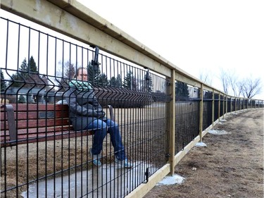 Bethany Wall looks through the fence to see the scenic view overlooking the Elbow River from Britannia Drive, in Calgary on February 17, 2015.