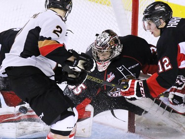 Calgary Hitmen Jake Bean looks to catch a rebound as the puck hits the pads of Prince George Cougars goaltender Ty Edmonds during second period WHL action at the Scotiabank Saddledome on Wednesday February 11, 2015.