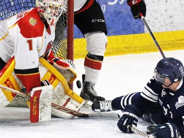 The Calgary Dinos' Kris Lazaruk stopped this scoring chance by the Mount Royal Cougars' Matthew Brown during the third period of the CIS Canada West men's semifinal series at Father David Bauer Arena on Friday evening February 27, 2014.