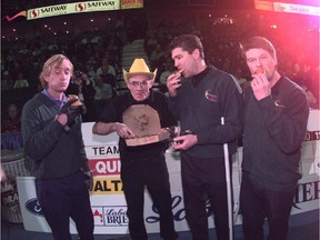 Paul Gowsell, left, savours a slice a pizza delivered by Shorty Jenkins, icemaker for the 1997 Brier in Calgary, along with former teammates Glen Jackson and Kelly Stearne. The scene was a re-creation of when the rink famously ordered a pizza and ate it on the ice while playing at an event in Regina.