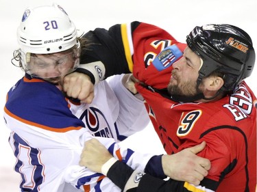 Edmonton Oilers Luke Gazdic, left and Calgary Flames Deryk Engelland fight it out during their game at the Scotiabank Saddledome  in Calgary on January 30, 2014.