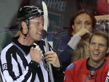 Linesmen David Brisebois gets Edmonton Oilers Anton Lander's stick caught in his helmet during their game at the Scotiabank Saddledome in Calgary on January 30, 2014.