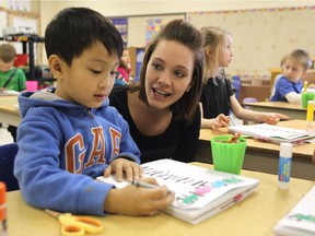 St. Damien School full-day kindergarten student Dioncarlo Murao works with teacher Laurel Hagel on his writing and art project. Reader says kids will lose out without full-day kindergarten.