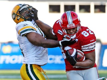 Calgary Stampeder Nik Lewis straight arms  Edmonton Eskimo T.J. Hill during a 2010 game. Lewis' physicality has been on full display for his Stamps career.