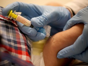 Pediatrician Dr. Amanda Porro M.D. delivers a flu vaccination to an infant's leg during his visit to the Miami Children's Hospital on January 7, 2015 in Coral Gables, Florida.