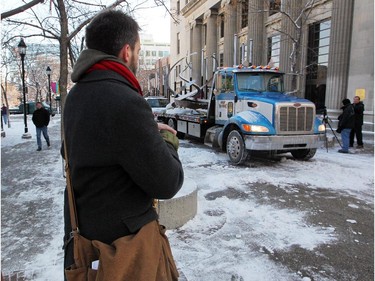 Occupy Calgary protestor Tavis Ford watches as the sculpture left by the Occupy Calgary protestors was removed from Calgary's Olympic Plaza on December 12, 2011.