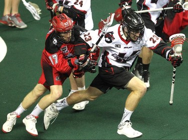 Calgary Roughnecks forward Curtis Dickson, left, laid some pressure on Vancouver Stealth transition Conrad Chapman during first half National Lacrosse League action at the Scotiabank Saddledome on February 21, 2015.