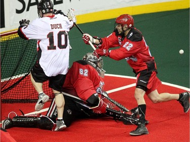 Calgary Roughnecks defenceman Scott Carnegie rushed Vancouver Stealth forward Rhys Duch into the net of Roughnecks goalie Frankie Scigliano during first half National Lacrosse League action at the Scotiabank Saddledome on February 21, 2015.