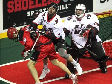 Calgary Roughnecks transition Curtis Manning and Vancouver Stealth defenceman Chris O'Dougherty got caught up with each other just outside the crease of goalie Tyler Richards during first half National Lacrosse League action at the Scotiabank Saddledome on February 21, 2015.