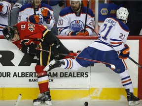 Edmonton Oilers' Andrew Ference, right, checks Calgary Flames' David Wolf during the first period on Saturday night. Wolf made his NHL debut in the contest.