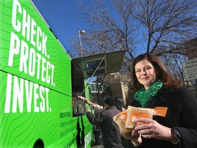 Alison Trollope, of the Alberta Securities Commission, with free sandwiches that ASC handed out from a food truck to Calgarians over the lunch hour, in Calgary on March 13, 2014.