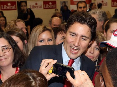 Federal Liberal leader Justin Trudeau has his photo taken amidst the mob scene as he makes his way through the crowd following his  speech at the Kerby Centre Thursday night February 5, 2015.