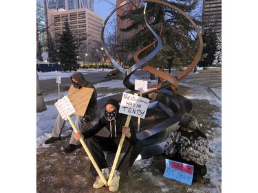Occupy Calgary protestors sit with a sculpture at the site of Occupy Calgary at Olympic Plaza in Calgary Friday, December 9, 2011.