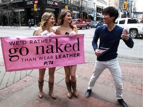 Mostly naked People for the Ethical Treatment of Animals protesters Emily Lavender, right, and Amy Balcome,  chat with curious passerby Matthew Hwang Tuesday Febraury 24,  on Stephen Avenue. The 2 women, wearing vegan cowboy boots and little else, passed out leaflets urging people to avoid leather shoes or bags in favour of vegan leather.