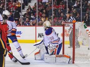 Paul Byron of the Calgary Flames scores against Ben Scrivens of the Edmonton Oilers on Saturday.