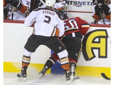 Calgary Flames' Markus Granlund takes a hit into the Anaheim Ducks bench from Clayton Stoner during game action at the Saddledome in Calgary, on February 20, 2015.