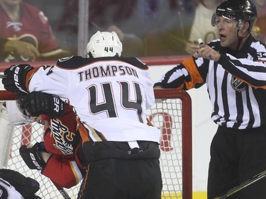 Calgary Flames' Sean Monahan takes a cross check to the back of the head from Anaheim Ducks' Nate Thompson during game action at the Saddledome in Calgary, on February 20, 2015.