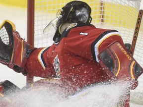Calgary Flames goalie Jonas Hiller can't make it to this save during game action against the Anaheim Ducks at the Saddledome in Calgary, on February 20, 2015.