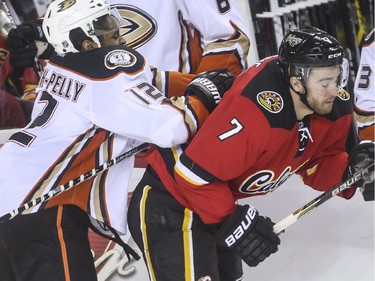 Calgary Flames TJ Brodie takes a hit from Anaheim Ducks' Devante Smith-Pelly during game action at the Saddledome in Calgary, on February 20, 2015.