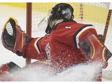 Calgary Flames goalie Jonas Hiller can't get a mit on this one during game action against the Anaheim Ducks at the Saddledome in Calgary, on February 20, 2015.