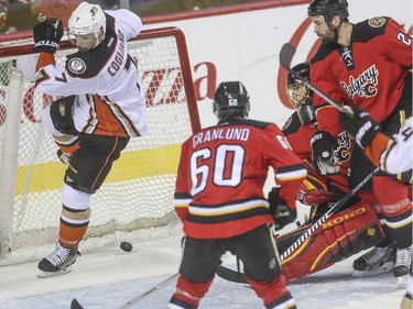 The Flames watch as Anaheim Ducks' Andrew Cogliano pop the puck in the net the knocks it out of place during game action at the Saddledome in Calgary, on February 20, 2015.