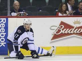 Calgarian Adam Lowry stretches during warm-ups as his Winnipeg Jets got ready to face the Calgary Flames at the Scotiabank Saddledome on Monday. Lowry, who grew up as a rink rat at the arena where his dad was a player for the Flames, played his first NHL game at the Dome.